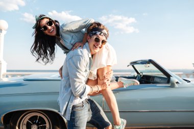 Onun kadın vintage cabriolet önünde taşıyan adam