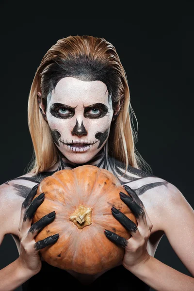 Närbild av kvinna med gotiska skelett makeup hålla pumpa — Stockfoto