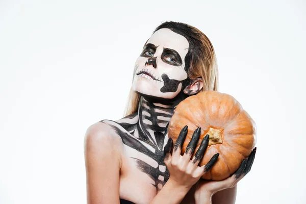 Porträtt av kvinna med halloween skelett makeup hålla pumpa — Stockfoto