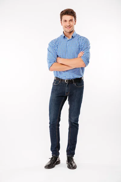 Full length of happy young man standing with arms crossed — Stock Photo, Image