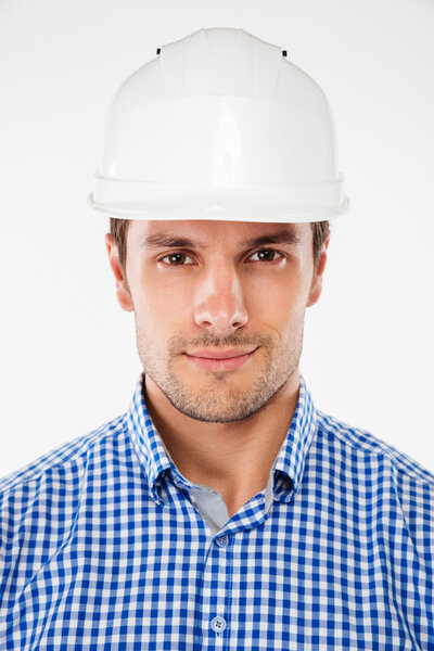 Крупный план серьезного молодого инженера-строителя в шлеме
