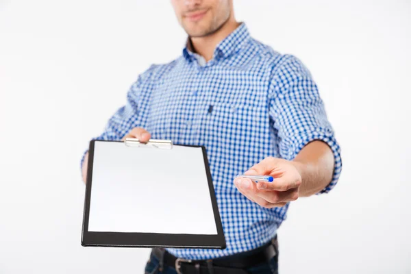 Handsome man architect in hard hat giving you blank clipboard — Stock Photo, Image