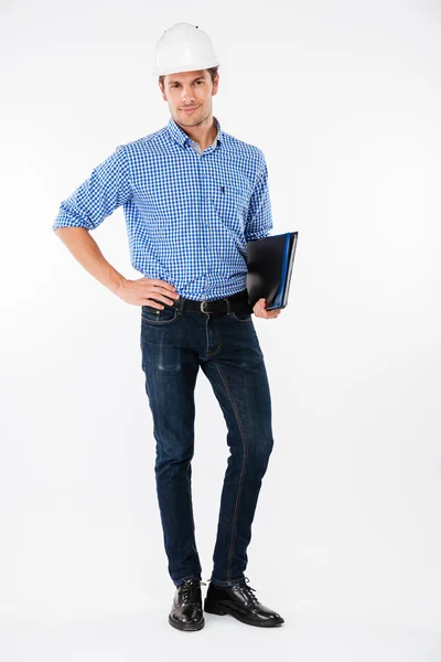 Confident man builder in hard hat standing and holding folder — Stock Photo, Image