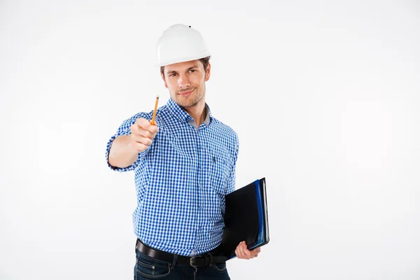 Gelukkig jongeman architect in harde hoed aan u te wijzen — Stockfoto