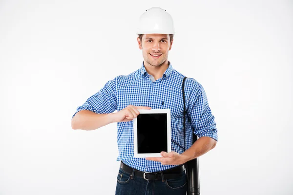 Construtor de homem alegre em chapéu duro mostrando tablet tela em branco — Fotografia de Stock