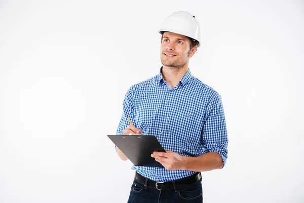 Ingénieur construction homme en chapeau dur écriture sur presse-papiers Photos De Stock Libres De Droits