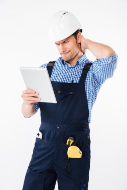 Başını tırmalamak ve tablet tutan kask içinde karışık Oluşturucu