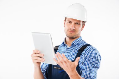 Başını tırmalamak ve tablet tutan kask içinde karışık Oluşturucu