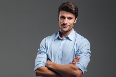 Kameraya bakarak katlanmış kollu yakışıklı işadamı