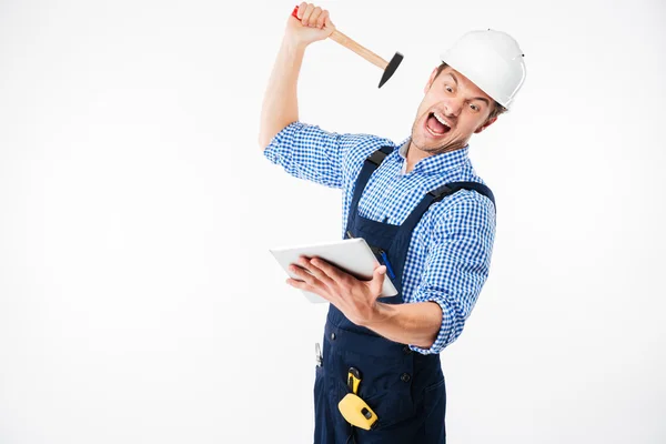 Портрет кричащего строителя, пытающегося сломать планшет — стоковое фото