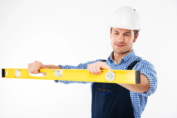 Porträt eines jungen Arbeiters in Overalls mit Levelwerkzeug — Stockfoto