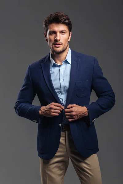 Portrait of a casual handsome man buttoning his jacket — Stock Photo, Image