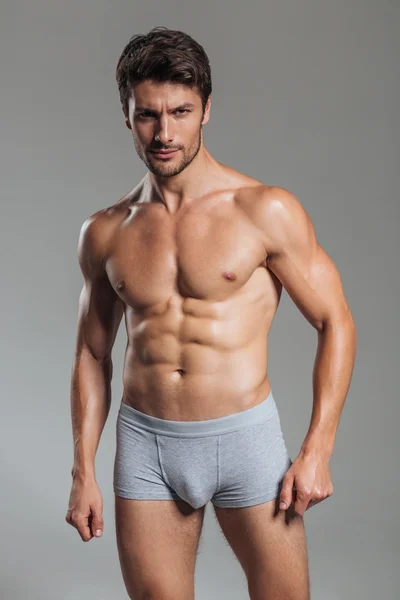 Porträtt av en allvarlig stilig muskulös man i underkläder stående — Stockfoto