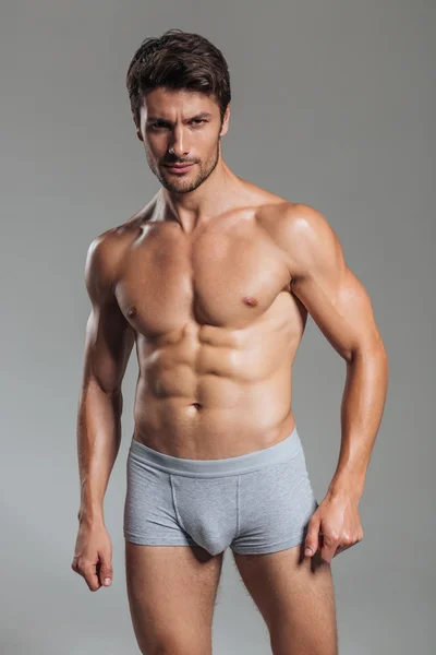 Portrait of a serious handsome muscular man in underwear standing — Stock Photo, Image