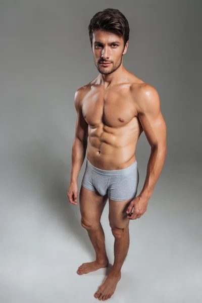 Portrait of a serious handsome muscular man in underwear standing — Stock Photo, Image