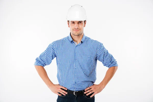 Sorrindo confiante jovem construtor na construção de capacete — Fotografia de Stock