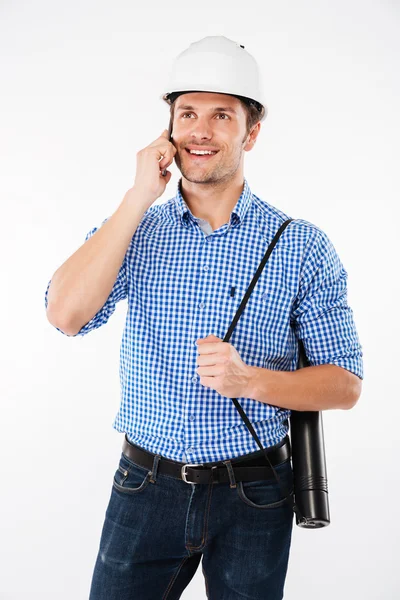 Веселий чоловік архітектор у будівництві шолома розмовляє на мобільному телефоні — стокове фото