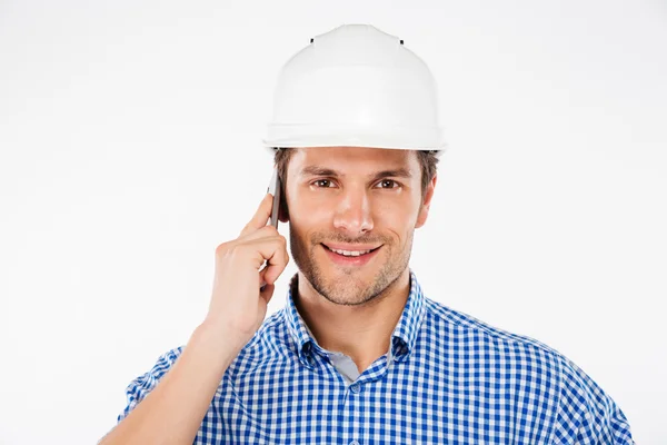 Mutlu bir adam binanın mühendisini cep telefonu üzerinde konuşurken kask içinde — Stok fotoğraf