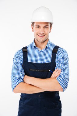 Kollarını kavuşturmuş miğferli genç adam miğferini takıyor.