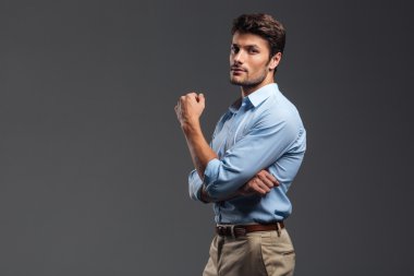 Silah ile başarılı yakışıklı bir adam yan görünüm katlanmış