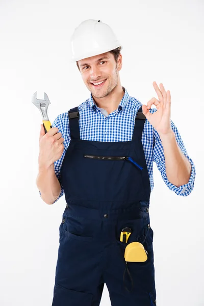 Constructor en la llave de sujeción del sombrero duro y mostrando signo ok —  Fotos de Stock