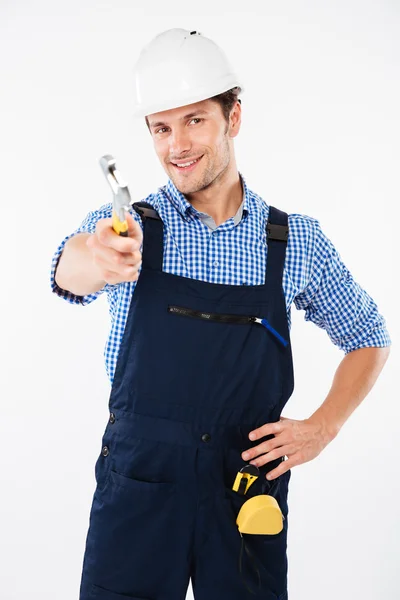 Gelukkig jongeman bouwer in helm holding moersleutel — Stockfoto