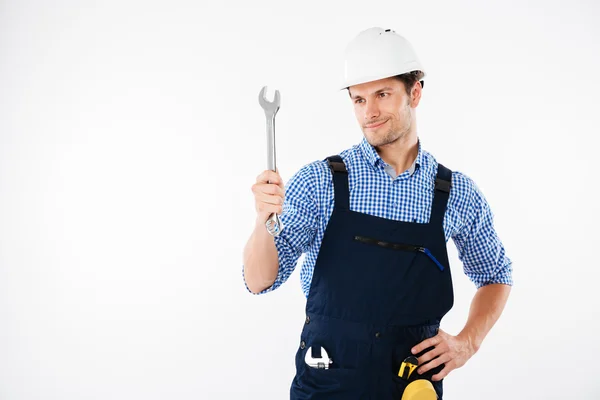 Sorrindo bonito construtor masculino segurando chave inglesa — Fotografia de Stock