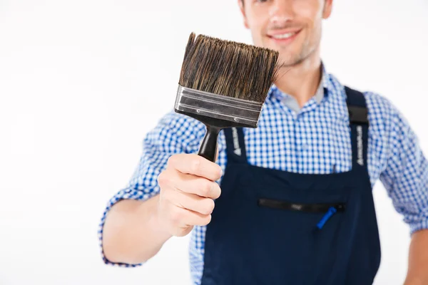 Обрізане зображення усміхненого чоловіка-будівельника, що тримає пензлик для фарби — стокове фото