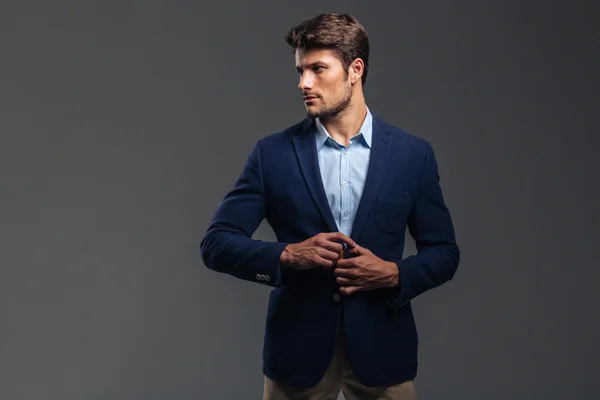 Portrait of a casual handsome man buttoning his jacket — Stock Photo, Image