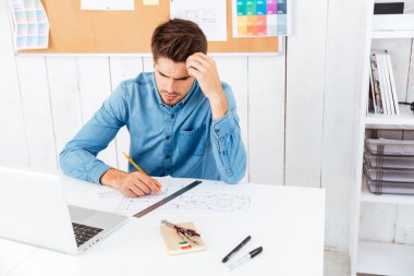 Ofiste dizüstü bilgisayar kullanarak bir şey düşünmeye işadamı