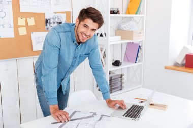 Office masada duran gülümseyen mutlu işadamı