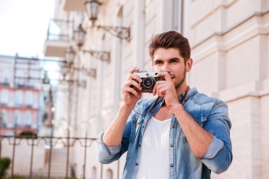 Şehirde eski fotoğraf makinesi ile pistures alan adam