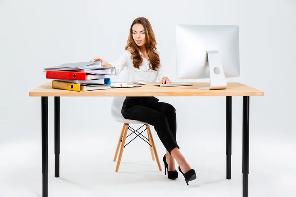 Atractiva empresaria que trabaja con documentos mientras está sentada a la mesa — Foto de Stock