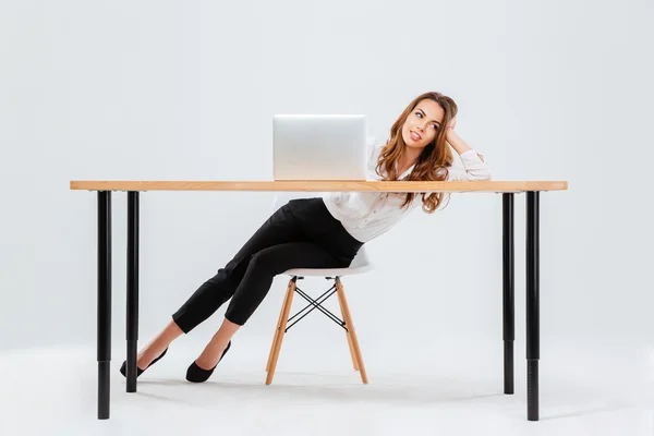 Mujer descansando mientras está sentado en el escritorio de la oficina con el ordenador portátil — Foto de Stock