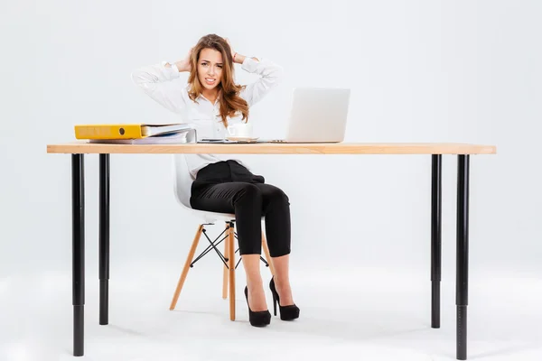 Verward in verlegenseerde jonge zakenvrouw die met laptop aan tafel werkte — Stockfoto