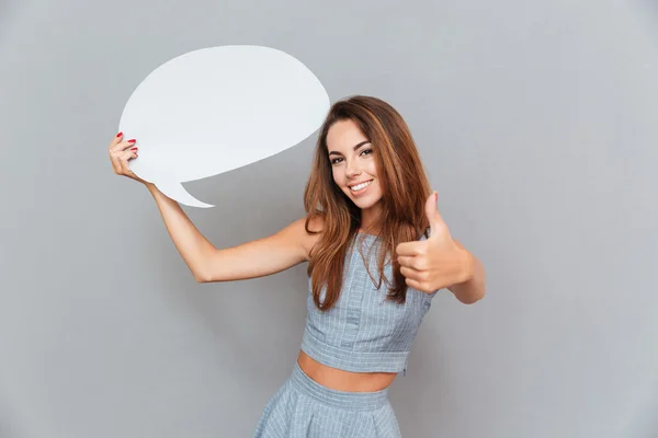 Mujer feliz sosteniendo burbuja de habla en blanco y mostrando los pulgares hacia arriba — Foto de Stock