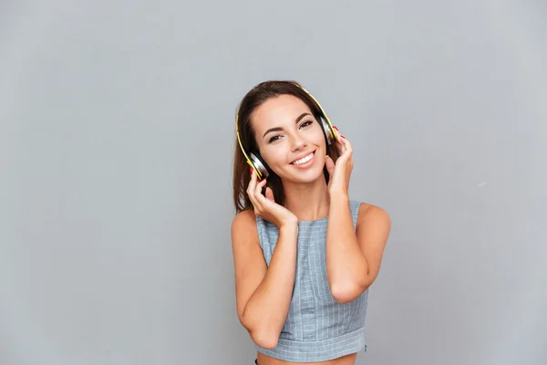 快乐的年轻女子用耳机听音乐 — 图库照片