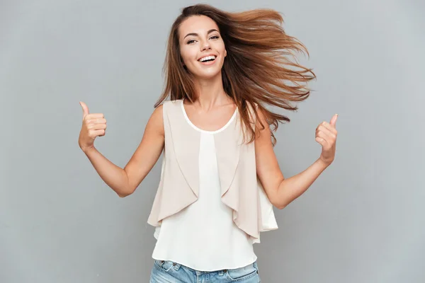 Portrait d'une jeune femme souriante décontractée montrant les pouces vers le haut — Photo