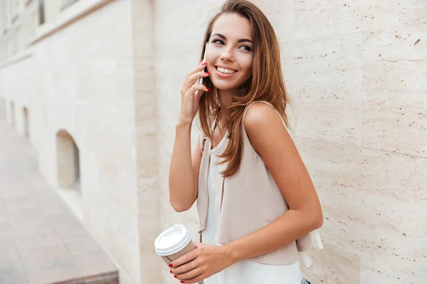 Mobil telefonda konuşurken ve kahve içme gülümseyen kız — Stok fotoğraf