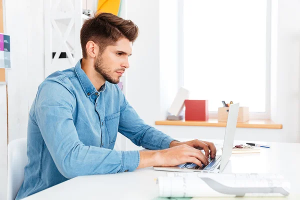 Portrait of a thoughtful casual businessman sitting at the desk — Stock Photo, Image