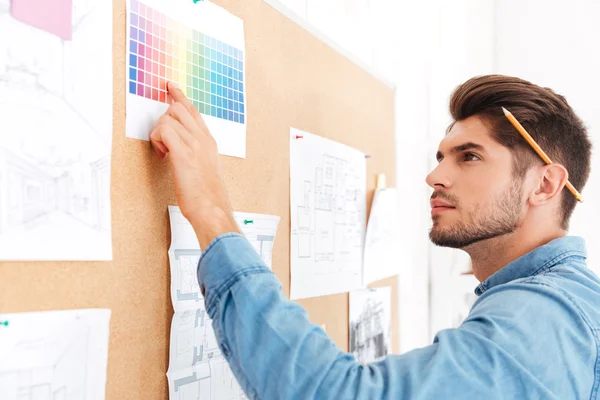 Casual zakenman wijzende vinger bij office board — Stockfoto