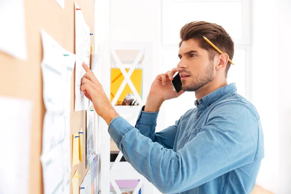 Jonge geconcentreerde casual zakenman praten aan de telefoon — Stockfoto