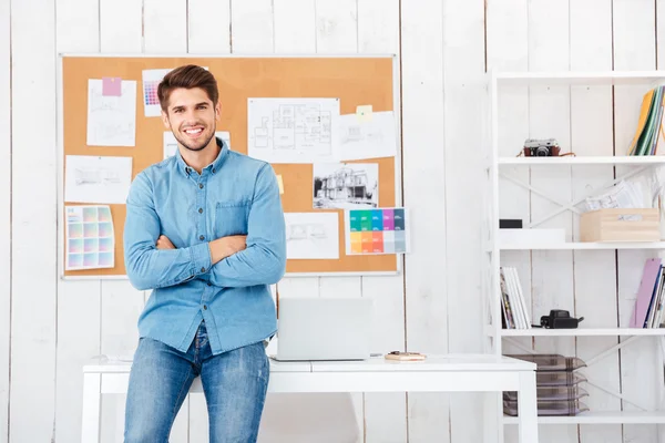 Feliz hombre de negocios sentado en el escritorio de la oficina con las manos dobladas — Foto de Stock