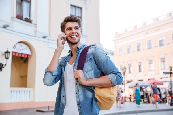 Hombre con mochila hablando por teléfono móvil en la ciudad — Foto de Stock