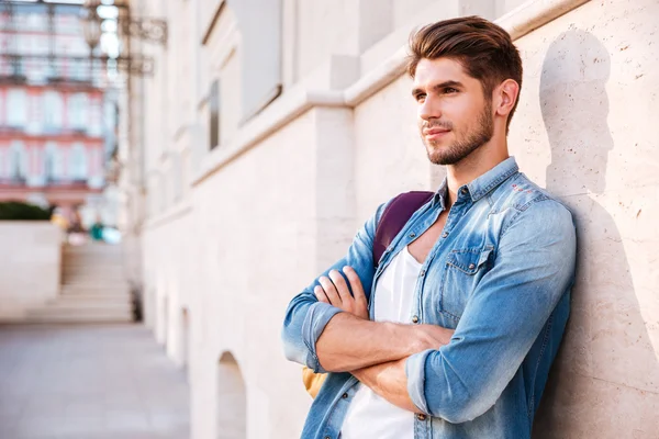 Man standing with arms folded and leaning on the wall — Stock Photo, Image