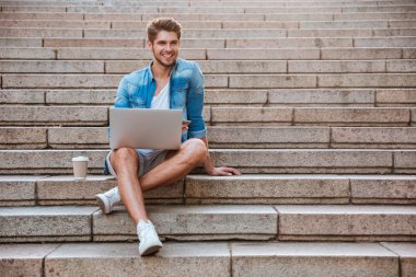 Merdivende dizüstü bilgisayar ile Adam öğrenci