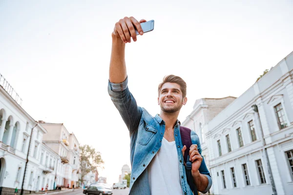 Turista con mochila haciendo selfies aislados en hermosos edificios modernos — Foto de Stock