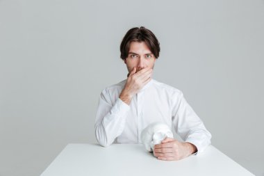 Dalgın adam masada otururken ağzı kapağı