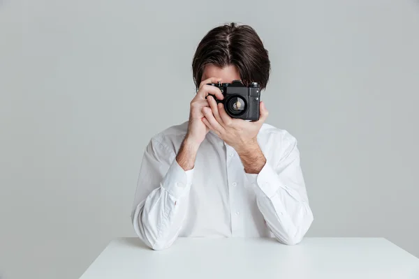 Man sitter vid bordet och göra foto med kameran — Stockfoto