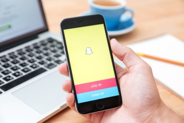 Snapchat uygulamasını gösteren iphone 6'yı tutan adam